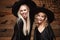 Halloween Concept - Closeup beautiful caucasian mother and her daughter in witch costumes celebrating Halloween posing with curved