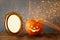 Halloween concept. Cute pumpkin next to blank photo frame