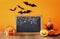 Halloween concept. Cute pumpkins next to blank blackboard