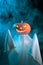 Halloween concept. A ghost with a creepy head glowing jack-o-lantern pumpkin stands in the fog at dusk.
