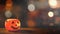 Halloween concept - Orange plastic pumpkin lantern on a dark wooden table with blurry sparkling light in the background, trick or