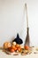 Halloween concept. Pumpkins, broom, witch hat on white wall background