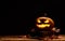 Halloween concept with scary luminous pumpkin on the old wood table with dark background