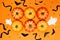 Halloween concept, Scary smile pumpkins with bat and ghost arranged in center of orange background