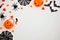 Halloween corner border of candy and decor, flat lay over white