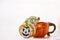 Halloween creative concept: pumpkin cup and homemade cute cookies in shape of cute pumpkins. Atmospheric aesthetic