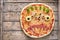 Halloween creative scary food monster zombie face with eyes pizza snack mozzarella, basil and sausage