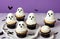 Halloween cupcakes decorated with ghost and bat shape on white table