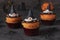 Halloween cupcakes decorated witch hat from mastic on gray background with spiders and bats. Sweets for kids on
