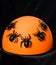 Halloween decor - lots of black spiders on an orange night light