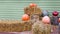 Halloween decor near wooden store wall with haystack and pumpkins.