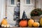Halloween decorated front door with various size and shape pumpkins and skeletons. Front Porch decorated for Halloween.