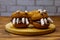 Halloween dessert: Toothed monsters made of oatmeal cookies, chocolate spread and marshmallows on wooden table