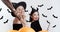 Halloween enchantresses. Two women in with costumes smiling and flirting at camera, holding broom and magic wand