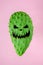 Halloween face on the green cactus on bright pink background.