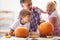 Halloween, family and carving a pumpkin with children at a home table for fun and bonding. Man or dad helping or