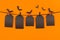 Halloween flock bats and black blank labels tomb hanging on clothespins, on orange background, mock up.