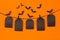 Halloween flock bats and black blank labels tomb hanging on clothespins, on orange background, mock up.