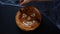 Halloween food. female hand decorating homemade pie with pumpkin face on wooden table with spider web