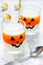 Halloween food idea: layered milk orange jelly in glasses on a w