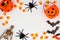 Halloween frame of scattered candy and decor over white