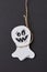 Halloween greeting card with laughing flying scary Casper hanging from a rope handmade from paper on a black .