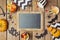 Halloween holiday background with chalkboard, pumpkin and candy.