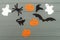 Halloween holiday background with three pumpkins, cat, spider, bat, hat and two ghosts