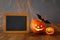 Halloween holiday concept. Cute pumpkins next to blank blackboard