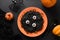 Halloween Italian black pasta decorated horror eyes in orange plate on black .