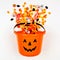 Halloween Jack o Lantern pail with spilling candy, top view on a white background