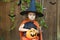 Halloween kids. funny little girl in orange witch costume, black hat with pumpkin Jack, bucket for sweet candy