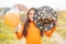 Halloween kids. Portrait of smiling girl with brown hair in witch hat. Holding orange balloon