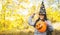 Halloween kids. Portrait smiling girl with brown hair in witch hat with pumpkin balloon