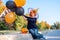 Halloween kids. smiling boy pumpkin face mask in witch hat with orange and black balloons. Funny child in carnival