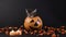 A Halloween kitten sits in a bucket of pumpkin, candy falls on top.