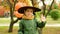 Halloween little boy waving his hand hello while standing in autumn park
