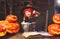 Halloween. little witch child cooking potion with pumpkin and