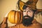 Halloween man with pumpkin - Holidays celebration concept. Scary hipster man with beard in Halloween hat. Bearded