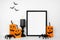 Halloween mock up black frame on a wood shelf with rustic wood jack o lantern decor, spiders and candle