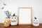 Halloween mock up wooden frame on a wood shelf with black branches and jack o lantern decor