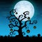 Halloween night background with hanging pumpkin on dry tree in graveyard