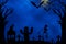 Halloween night with moon, tree, bats, skeleton, ghost on blue background