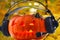 Halloween orange musical pumpkin in headphones with bright glowing eyes and a spider with red beady eyes