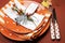 Halloween orange polka dot and stripes dinner table setting. Close up.