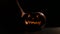 Halloween, orange pumpkin with a scary luminous face on a dark background. Puts a candle in jack-o-lantern. Close-up of