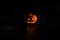 Halloween, orange pumpkin with a scary luminous face on a dark background. Thick gray smoke comes out and spreads across