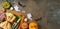 Halloween party banner concept with plate, pumpkin and decorations on dark background. Top view, flat lay