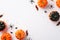 Halloween party decorations concept. Top view photo of small pumpkins insects spiders centipedes and black confetti on isolated