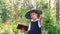 Halloween party. portrait of teen girl in witch costume. holding magic wand and book,